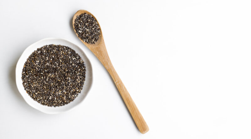 Biji chia hitam dan putih dalam sendok kayu yang menggambarkan manfaat chia seed untuk kesehatan tubuh.
